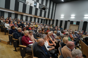 widok na seniorów siedzących w auli