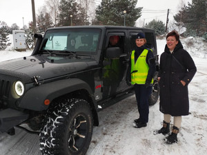 policjantka i przedstawicielka banku podczas akcji stoją przy kontrolowanym samochodzie terenowym