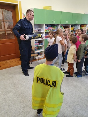 Policjant pokazuje dzieciom magiczna tubę.