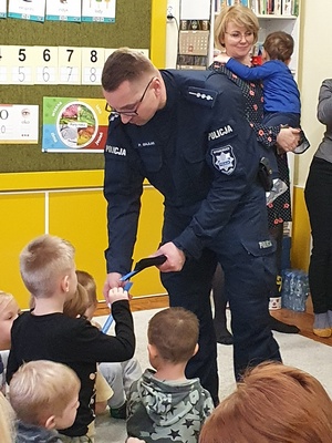 policjant wręcza dziecku odblask