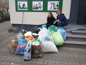 dwie kobiety kucają przy darach ułożonych przy schodach schroniska