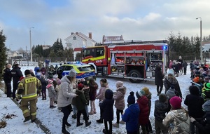 widok na pojazdy służbowe i stojące dookoła dzieci