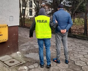 policjant prowadzi zatrzymanego