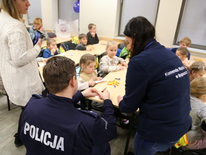 Policjanci podpisują kartki z imionami dla dzieci przewidziane do odcisków palców.