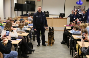 Środek sali, policjant z psem wychodzą z pokoju.