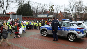 Policjant prezentuje sygnały dźwiękowe radiowozu.