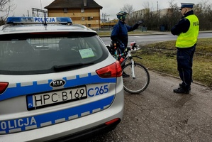 Policjant rozmawia z rowerzystą.