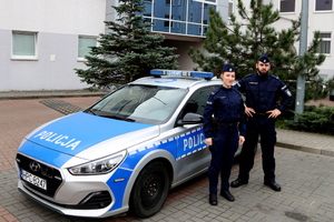 Policjant z policjantką przy radiowozie