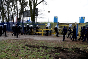 Policjanci reagują na szturm pozorantów przy bramie.