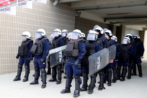 Policjanci stoją w przejściu podziemnym w gotowości do działań.