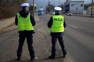 Dwóch policjantów stoi przy drodze