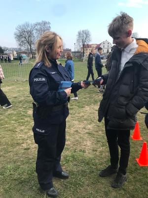 policjantka wręcza ulotkę chłopakowi