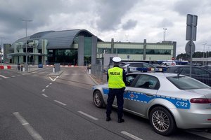 Policjant zabezpiecza wjazd na teren lotniska