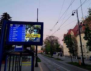 wyświetlacz na przystanku z policyjnym plakatem informacyjnym