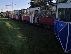 widok na tramwaje z boku, przy jednym z nich widoczna część policyjnego parawanu