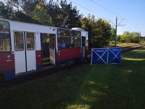 widok na bok tramwaju, przy którym stoi policyjny parawan