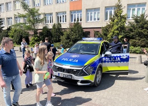 uczestnicy festynu i policjanci przy radiowozie