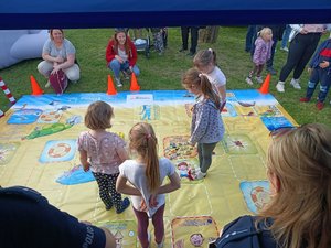 dzieci na macie edukacyjnej pod okiem policjantów