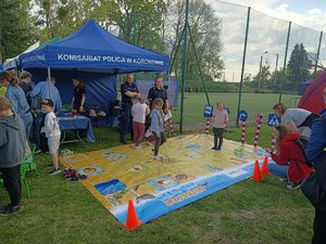 Policyjny namiot profilaktyczny, policjanci i mata edukacyjna podczas festynu.