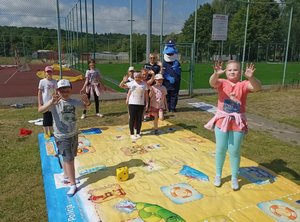 dzieci pod okiem policjantów grają w grę na macie edukacyjnej