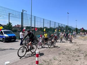 dzieci i dorośli jadą na rowerach