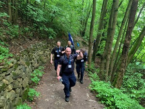 policjanci podczas marszu przez wzniesienie w lesie