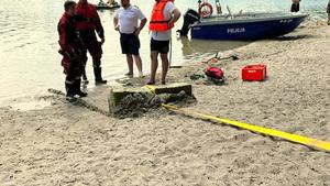 Betonowy słup ciągnięty na linie po plaży