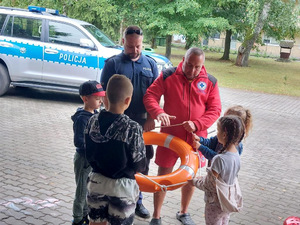 Policjant i ratownik WOPR podczas spotkania z dziećmi