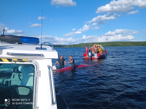 Policjanci i WOPR-owcy pomagają żeglarzom postawić łódź na wodzie