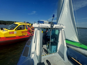 Policyjna motorówka na wodzie razem z motorówką ratowników WOPR