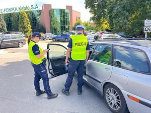 policjanci stoją przy otwartych drzwiach kierowcy