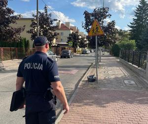 policjant kontroluje infrastrukturę drogową przy szkole