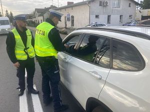 Policjanci kontrolują trzeźwość kierowcy białego samochodu.