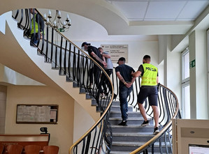 policjanci prowadzą zatrzymanych po schodach