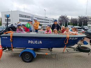 Dzieci stojące przed policyjną motorówką