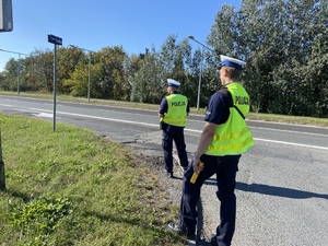 Policjanci ruchu drogowego podczas działań na drodze.