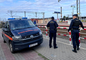 Policjant wraz z funkcjonariuszem Straży Ochrony Kolei podczas wspólnego patrolu w rejonie dworca PKP