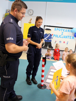 Policjant tłumaczący dzieciom zasady ruchu drogowego