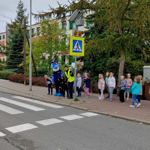 Dzieci wraz z policjantką i Polfinkiem podczas zajęć przy przejściu dla pieszych