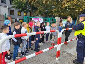 policjanci i dzieci podczas zajęć praktycznych na przejściu dla pieszych