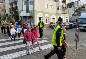 policjanci i dzieci podczas zajęć praktycznych na przejściu dla pieszych