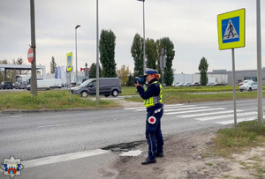 Policjantka Wydziału Ruchu Drogowego mierzy prędkość kierowców w rejonie przejścia dla pieszych