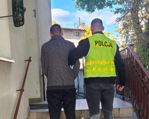 policjant prowadzi zatrzymanego