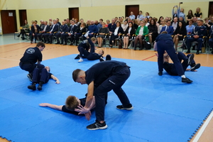 Ślubowanie uczniów klasy policyjnej i psychologiczno prawnej w szkole na sali gimnastycznej, gdzie uczestniczą w niej również zaproszeni goście oraz rodzice