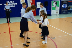 Ślubowanie uczniów klasy policyjnej i psychologiczno prawnej w szkole na sali gimnastycznej, gdzie uczestniczą w niej również zaproszeni goście oraz rodzice