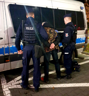 Mężczyzna trzymany przez dwóch policjantów