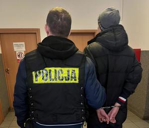 policjant prowadzi zatrzymanego