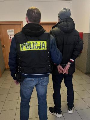 policjant prowadzi zatrzymanego