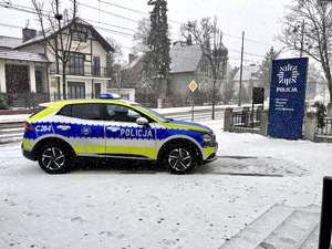 Oznakowany radiowóz stojący na parkingu przy drodze