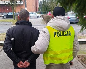 policjant prowadzi zatrzymanego